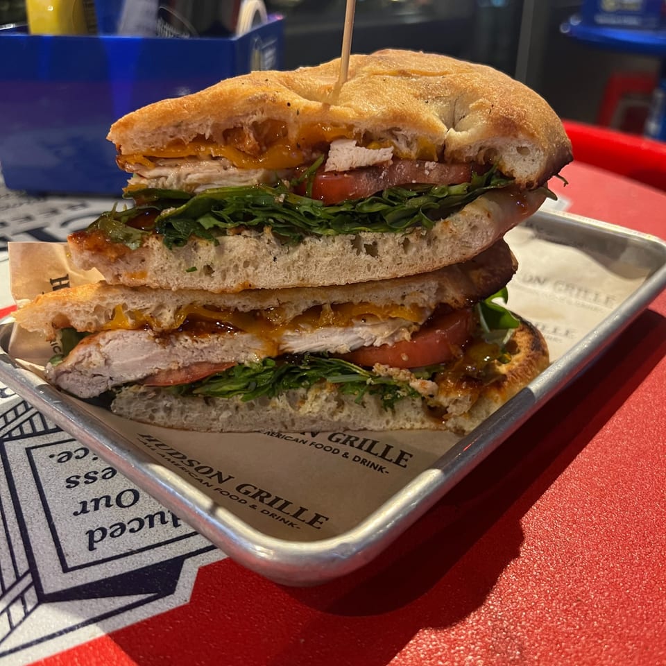 Chicken sandwich with cheese, greens and tomato at Hudson Grille.